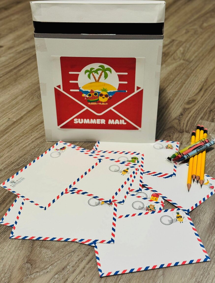 A child dropping a letter into the Summer Mail box