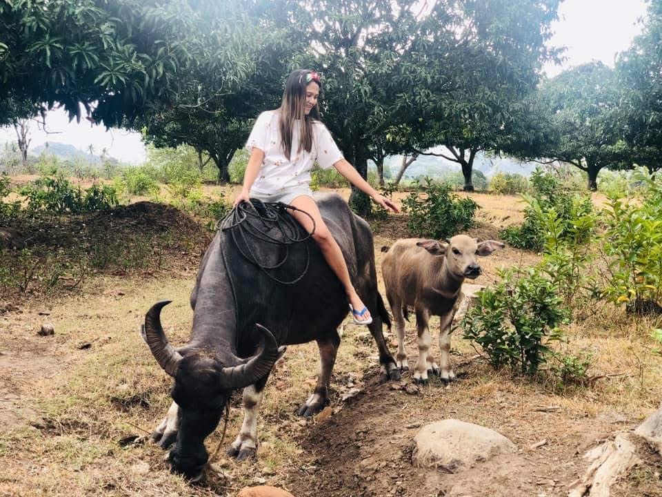 Young Jowena riding a water buffalo on the family farm in the Philippines